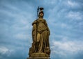 A statue in front of dark puffy clouds Royalty Free Stock Photo