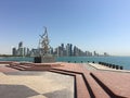 Statue in front of the Doha skyline