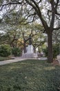 A statue of General James Edward Oglethorpe at Franklin Square with lush green weeping willow trees, plants and grass in Savannah