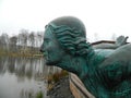 Statue of a girl on the Bank of a pond