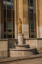 Statue of golden woman and dove in front of building at Trocadero in Paris.