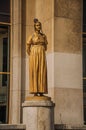 Statue of golden woman and dove in front of building at Trocadero in Paris.