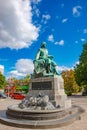 Statue of great scientist Otto Guericke in Magdeburg and coming by a red two decks sightseeing bus at blue sky and sunny day,
