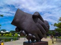 statue of hands shaking hands at Kiara Artha Park Bandung.