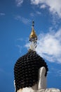 Statue of head buddha and cha-da on head with clound and blue sk