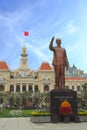 Statue of Ho Chi Minh with vietnamese flag in the background, in front of Saigon City Hall, Vietnam.