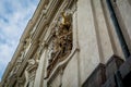 Statue holding a golden cross on the side of a building in Prague Royalty Free Stock Photo