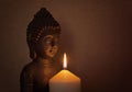 Statue of a holy Buddha in the light of a candle