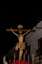 Statue of Jesus Christ hangs on the cross at night with lit candles at the religious processions