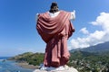 A statue of Jesus Christ laid on a hill, facing the ocean and a village in Flores, East Nusa Tenggara, Indonesia