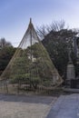 Statue of Jizo statue symbol of filial piety to protect children and a japanese pine protected by a winter umbrella in the Tennoji