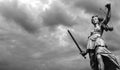 Statue of justice goddess Justitia with cloudy sky, Black and