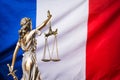 The statue of justice Themis or Justitia, the blindfolded goddess of justice against the flag of France, as a legal concept Royalty Free Stock Photo