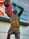 A statue of Kareem Abdul-Jabbar shooting a basketball with his sky hook shot wearing a Lakers uniform