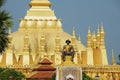 Statue of the King Chao Anouvong with the Pha That Luang stupa at the background in Vientiane, Laos. Royalty Free Stock Photo