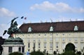 Statue with knight on rampant horse and with flag in his right hand, placed in front of the facade of a historic building in Vienn