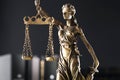 Statue of Lady Justice on dark background, closeup. Symbol of fair treatment under law