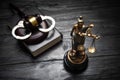 Statue of Lady Justice, handcuffs, book and gavel