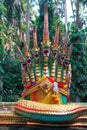 Statue of a large green Naga serpent with golden fins, with seven heads.