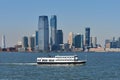 A Statue of Liberty Ferry in New York Harbor. In the background is the skyline of the Jersey City Waterfront at Exchange Place