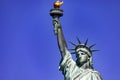 The Statue of Liberty holding her torch on a sunny day, under a clear blue sky. Royalty Free Stock Photo