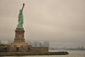 Statue of Liberty and Manhattan on a cloudy and foggy day Royalty Free Stock Photo