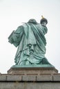 Statue of Liberty in New York City seen from the Back with a white Background, during a cloudy day in Fall Royalty Free Stock Photo