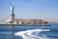 Statue of Liberty in NY Harbor with racing US Coast Guard Patrol Boat