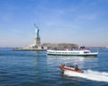 Statue of Liberty in NY Harbor with tourist boat and US Coast Guard