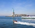 Statue of Liberty in NY Harbor with tourist boat and US Coast Guard