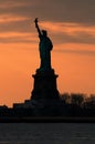 Silhouette of Statue of Liberty against a vivid orange sunset sky concept for NYC landmarks, American patriotism and symbol of fre Royalty Free Stock Photo