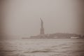 Statue of Liberty Silhouette as Seen from Lower Manhattan on a Foggy Day of Winter in New York City, USA Royalty Free Stock Photo