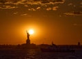 The Statue of Liberty at sunset with the sun just above Liberty`s shoulder Royalty Free Stock Photo