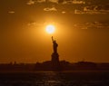 The Statue of Liberty at sunset with the sun just above the torch Royalty Free Stock Photo