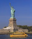 The statue of Liberty with yellow water taxi boat on the foreground, New York City Royalty Free Stock Photo