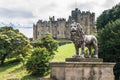 Statue of lion with Alnwick Castle and grounds