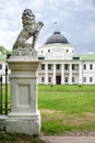 Statue of lion holding a shield in its paws. Regal lion leaning on empty heraldic shield near the castle entrance. The palace and Royalty Free Stock Photo