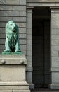 Statue of a lion standing guard in front of stone brick building Royalty Free Stock Photo
