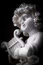 Statue of Little Cupid playing harp Royalty Free Stock Photo