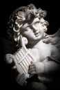 Statue of Little Cupid playing harp Royalty Free Stock Photo