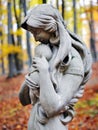 Statue of Madonna and child in autumn forest