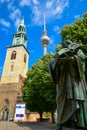 The statue of Martin Luther, the great reformer in front of Marienkirche with the backdrop of Fernsehturm TV Tower in Berlin