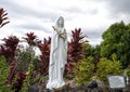 Statue of Mary with a lei outside Saint Benedict`s Painted Church on the Big Island, Hawaii.