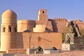 Statue of Mathematician Al Khoresmy with the city walls of Khiva in the background, Khiva