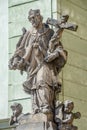 Statue of old priest with cross and Jesus at Old Town in Prague, Czech Republic