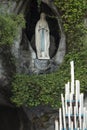 Statue of Our Lady of Immaculate Conception with a rosary in the Grotto of Massabielle in Lourdes Royalty Free Stock Photo