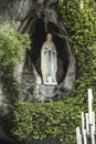 Statue of Our Lady of Immaculate Conception with a rosary in the Grotto of Massabielle in Lourdes Royalty Free Stock Photo