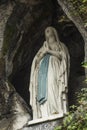 Statue of Our Lady of Immaculate Conception with a rosary in the Grotto of Massabielle in Lourdes Royalty Free Stock Photo