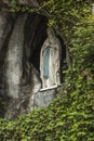 Statue of Our Lady of Immaculate Conception with a rosary in the Grotto of Massabielle in Lourdes Royalty Free Stock Photo