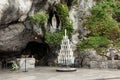 Statue of Our Lady of Immaculate Conception with a rosary in the Grotto of Massabielle in Lourdes Royalty Free Stock Photo